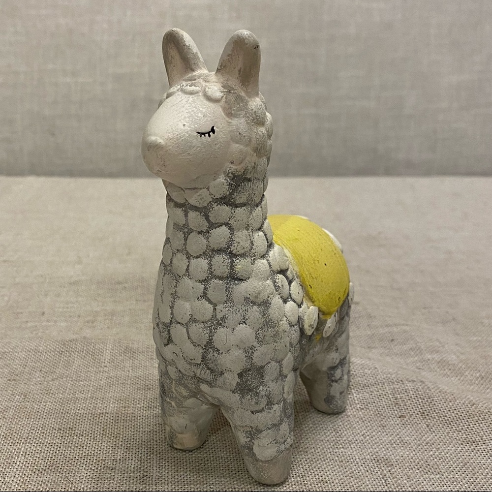 Small hand painted ceramic llama with yellow back cover.